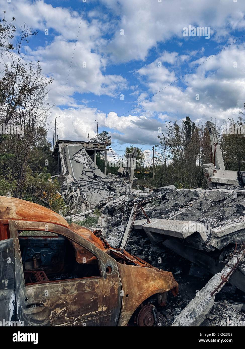 Destroyed bridge and burnt cars in liberated from occupation Kupiansk town in Kharkiv region in Ukraine. Result of Russian bombardment. Concept of war Stock Photo