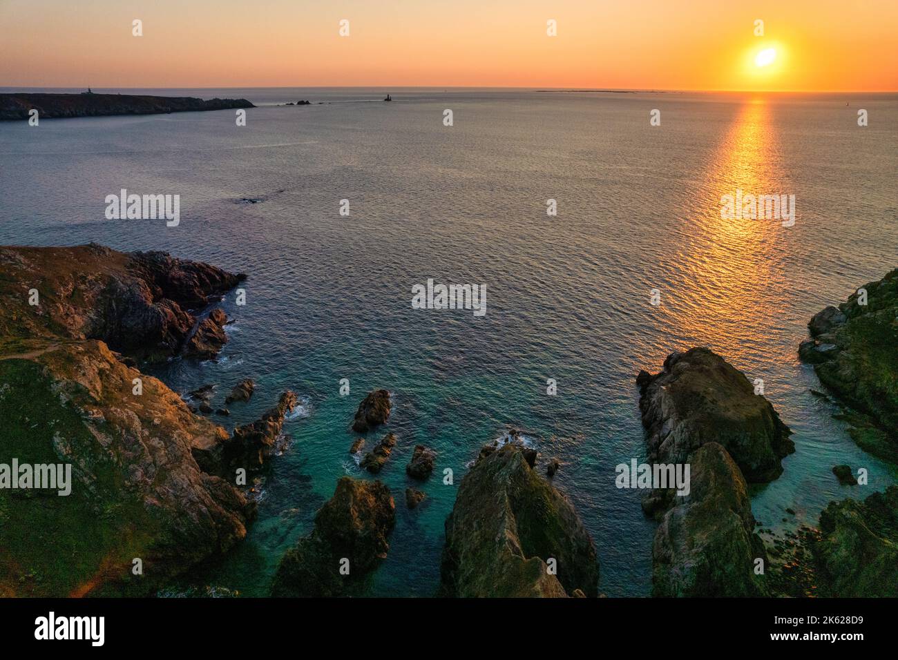 Aerial shot of a warm sunset over the ocean at the Torche point, Brittany, France Stock Photo