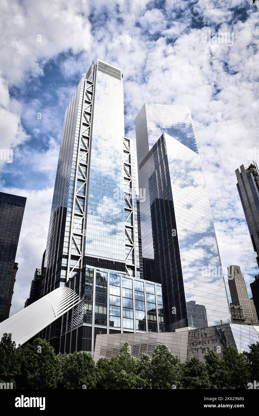 A vertical shot of New York skyscrapers reflecting the cloudy sky Stock ...