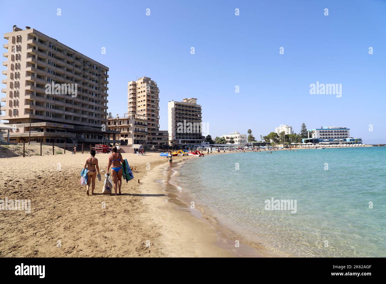 Tourists on Palm Beach next to Beachfront Hotels abandoned in 1974 when the Turkish Army invaded Northern Cyprus; Famagusta (Gazimagusa); Cyprus Stock Photo