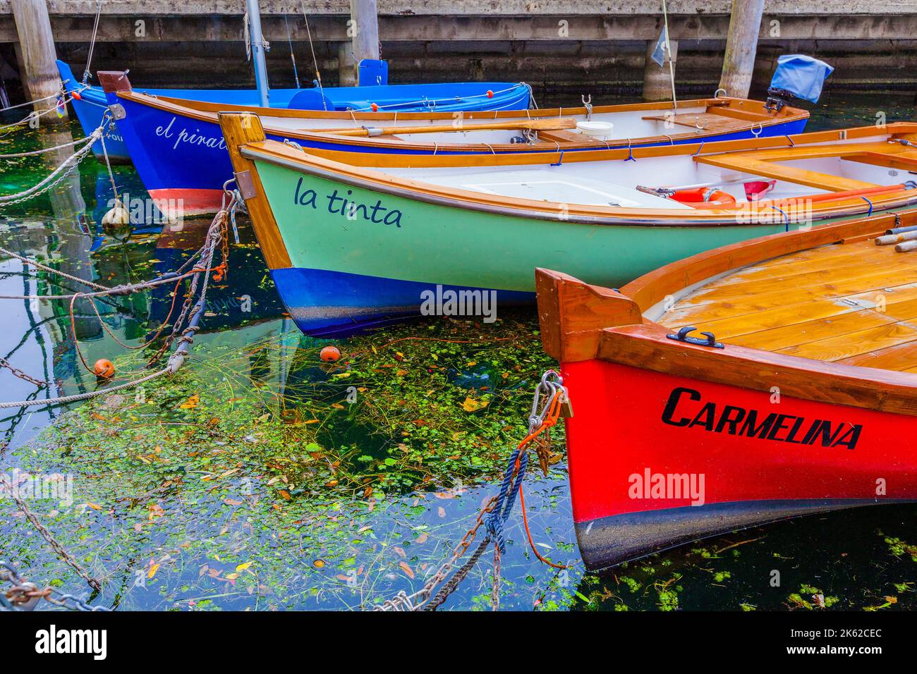 Old and colorful fishing boats in the habor of Torbole on lake Garda ...