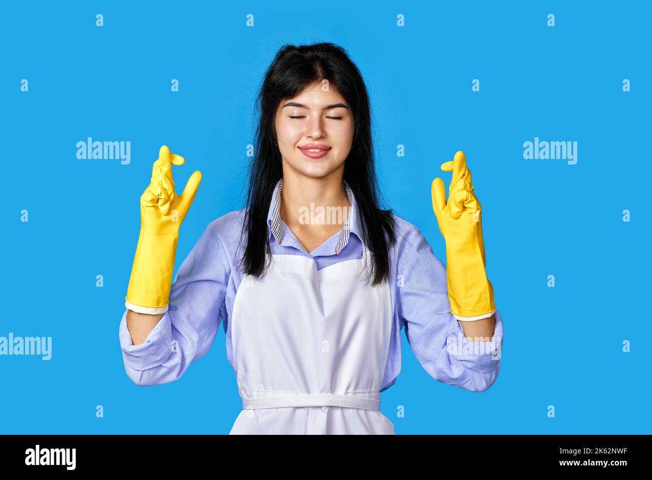 woman in rubber gloves with finger crossed gesture Stock Photo - Alamy