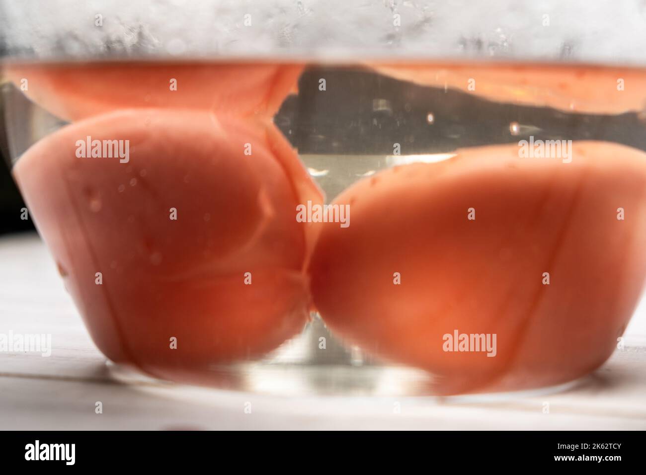 Peeling tomatoes in boiling water. Tomatoes in a bowl soaked in hot