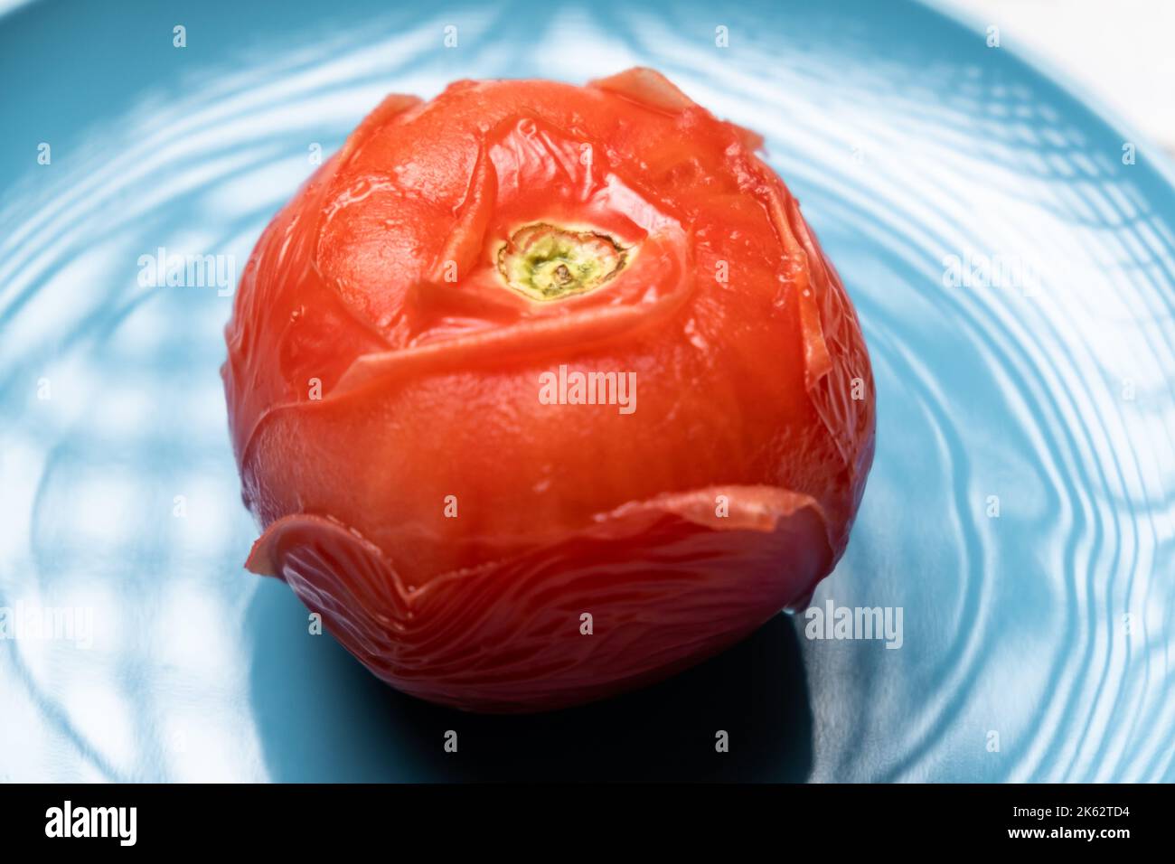 Peeling tomatoes in boiling water. Tomato after being in hot water