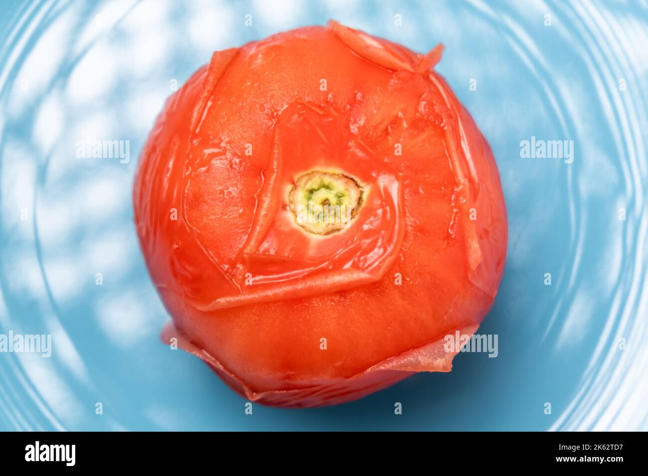 Peeling tomatoes in boiling water. Tomato after being in hot water