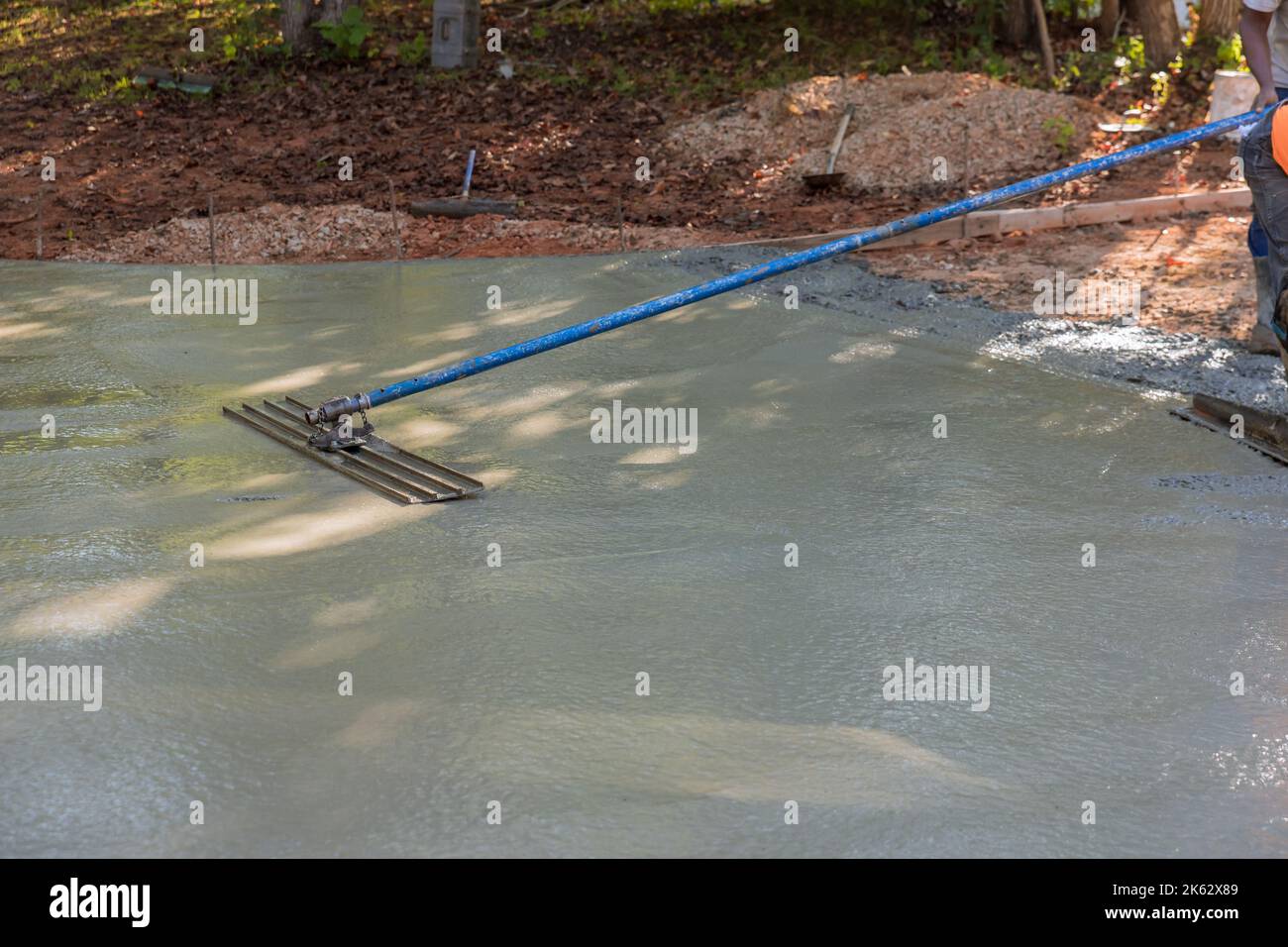 In order to level out cement concrete patio floor mason worker used