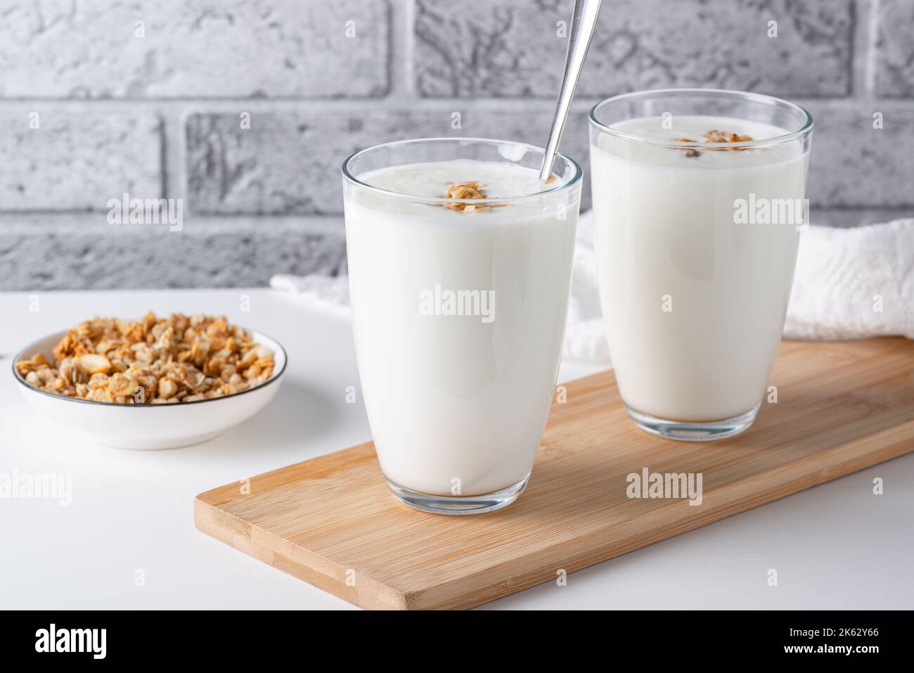 Kefir, buttermilk or yogurt with granola. Yogurt in glass on light