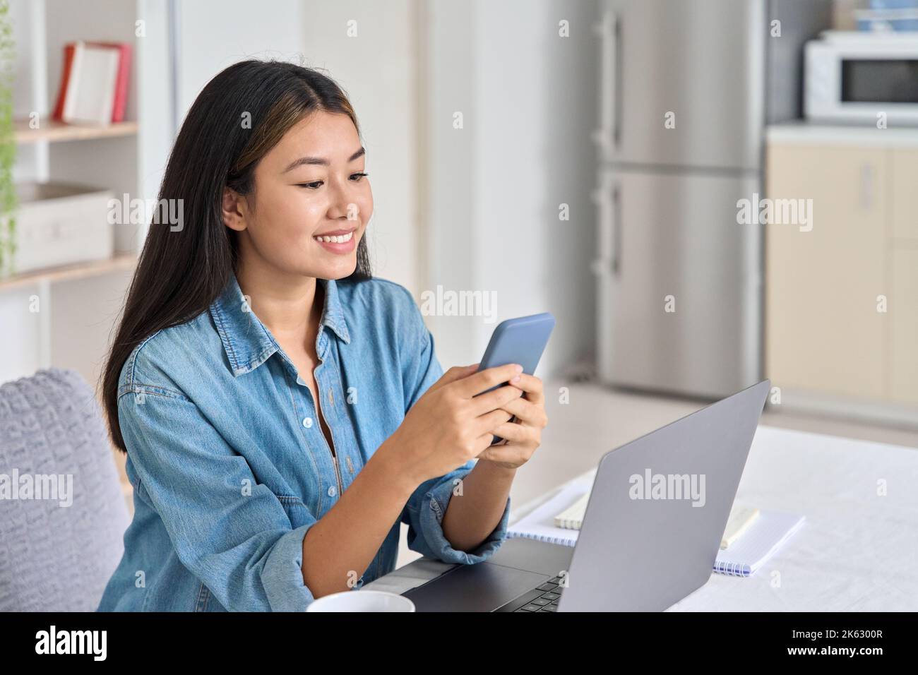 Young asian woman freelancer using mobile phone app for online video call Stock Photo