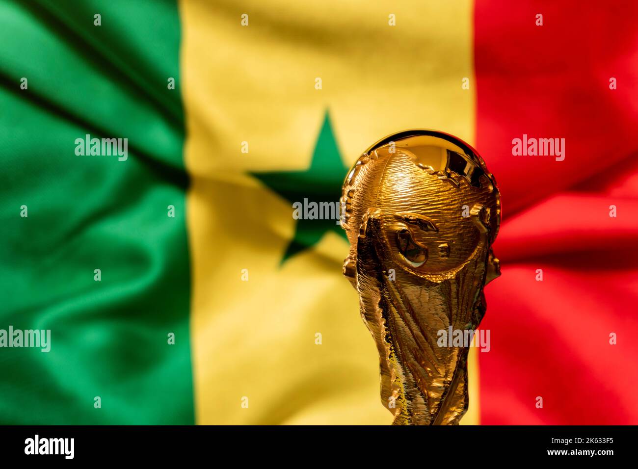 FIFA World Cup trophy against the background of Senegal flag. Stock Photo