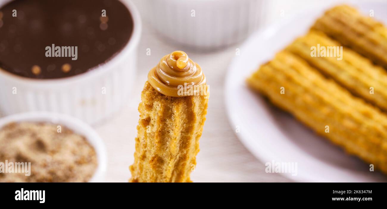 Churros, typical fried sweet from Brazil, Mexico and Spain. Sprinkled with a layer of sugar or cinnamon, filled with chocolate or dulce de leche Stock Photo