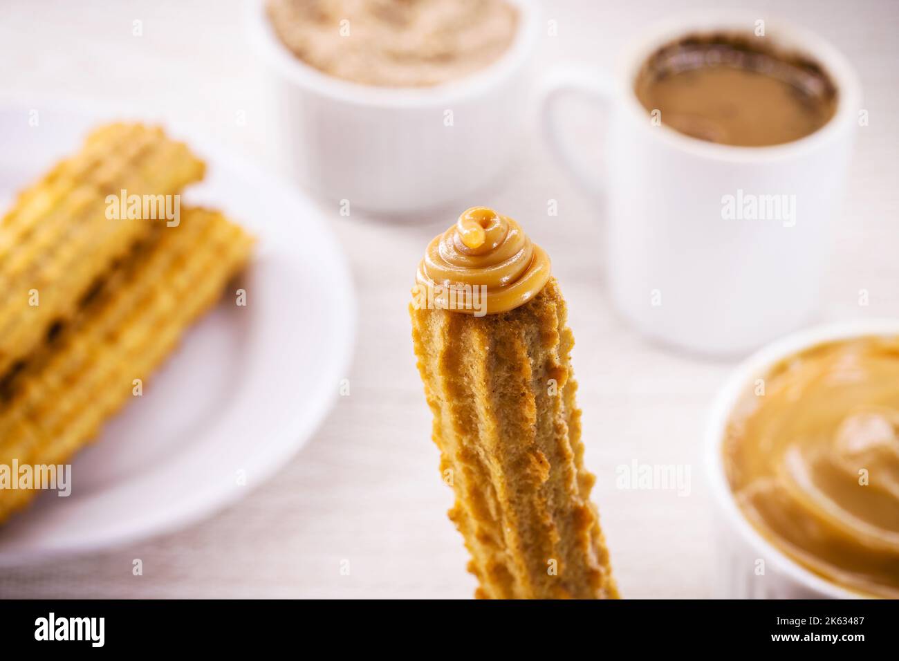 Churros, typical fried sweet from Brazil, Mexico and Spain. Sprinkled with a layer of sugar or cinnamon, filled with chocolate or dulce de leche Stock Photo