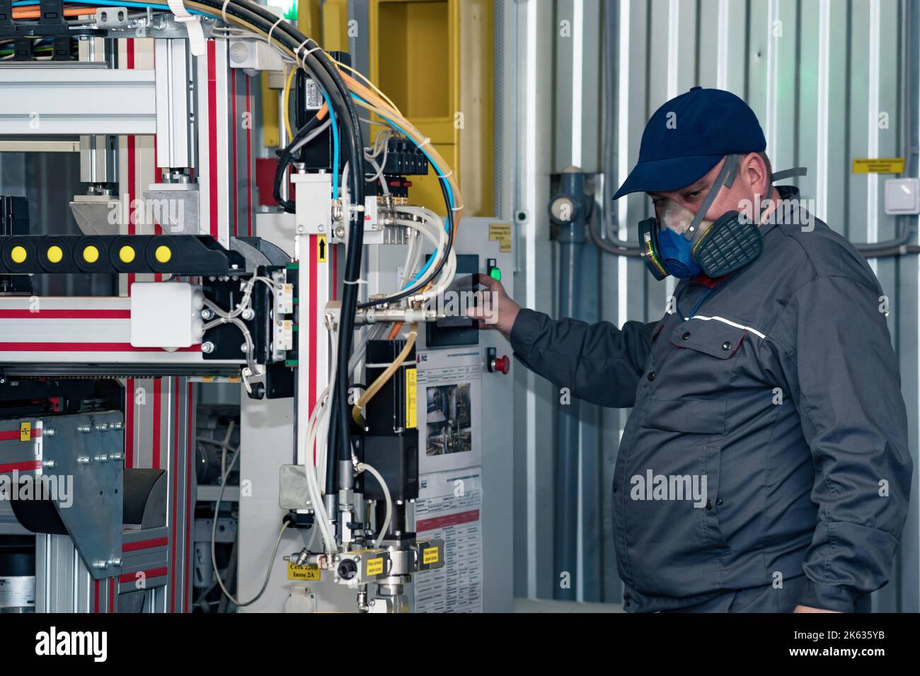 Perm, Russia - September 21, 2022: operator of industrial robotic dosing dispenser machine at work Stock Photo