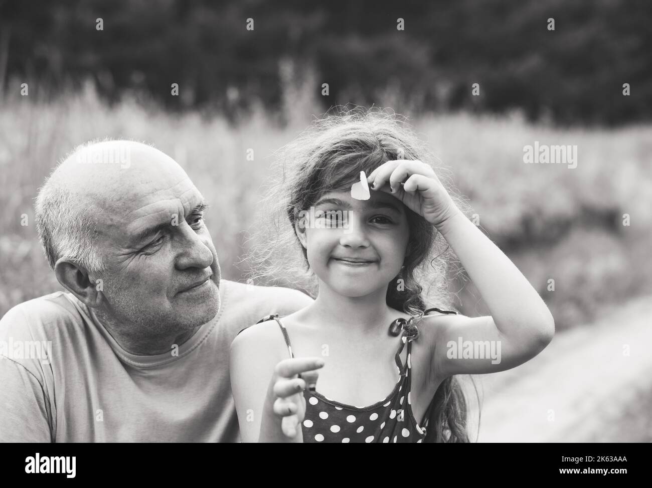 Portrait of granddad and granddaughter smiling at the park Stock Photo