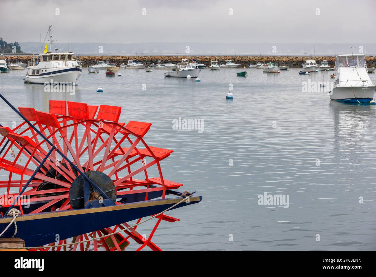 Plymouth, Massachusetts, USA - September 12, 2022:  Red paddlewheel in foreground with boats anchored in Plymouth Harbor on Cape Bay. Stock Photo