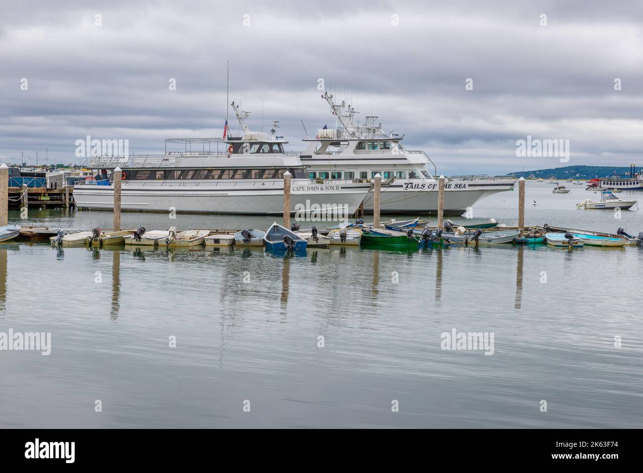 Plymouth, Massachusetts, USA - September 12, 2022: two large boats and several tenders docked in Plymouth Harbor on Cape Bay under cloudy skies. Stock Photo