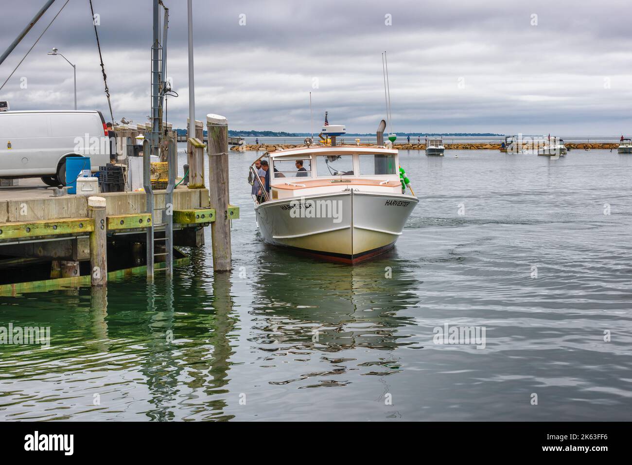 Plymouth, Massachusetts, USA - September 12, 2022: Fishing boat docking at peir to unload it's catch on Cape Bay at Plymouth Harbor. Stock Photo