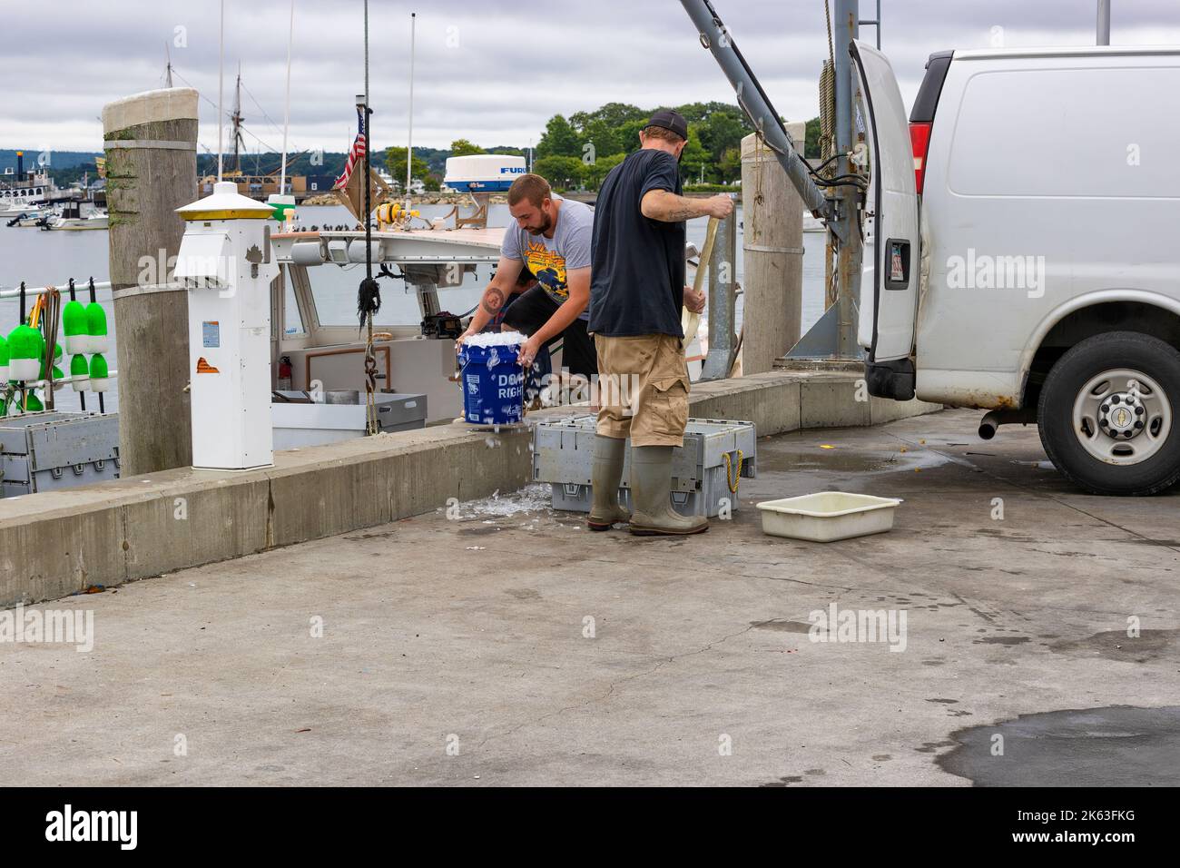 Plymouth, Massachusetts, USA - September 12, 2022: Fisher men refilling his fish storage with ice. Stock Photo