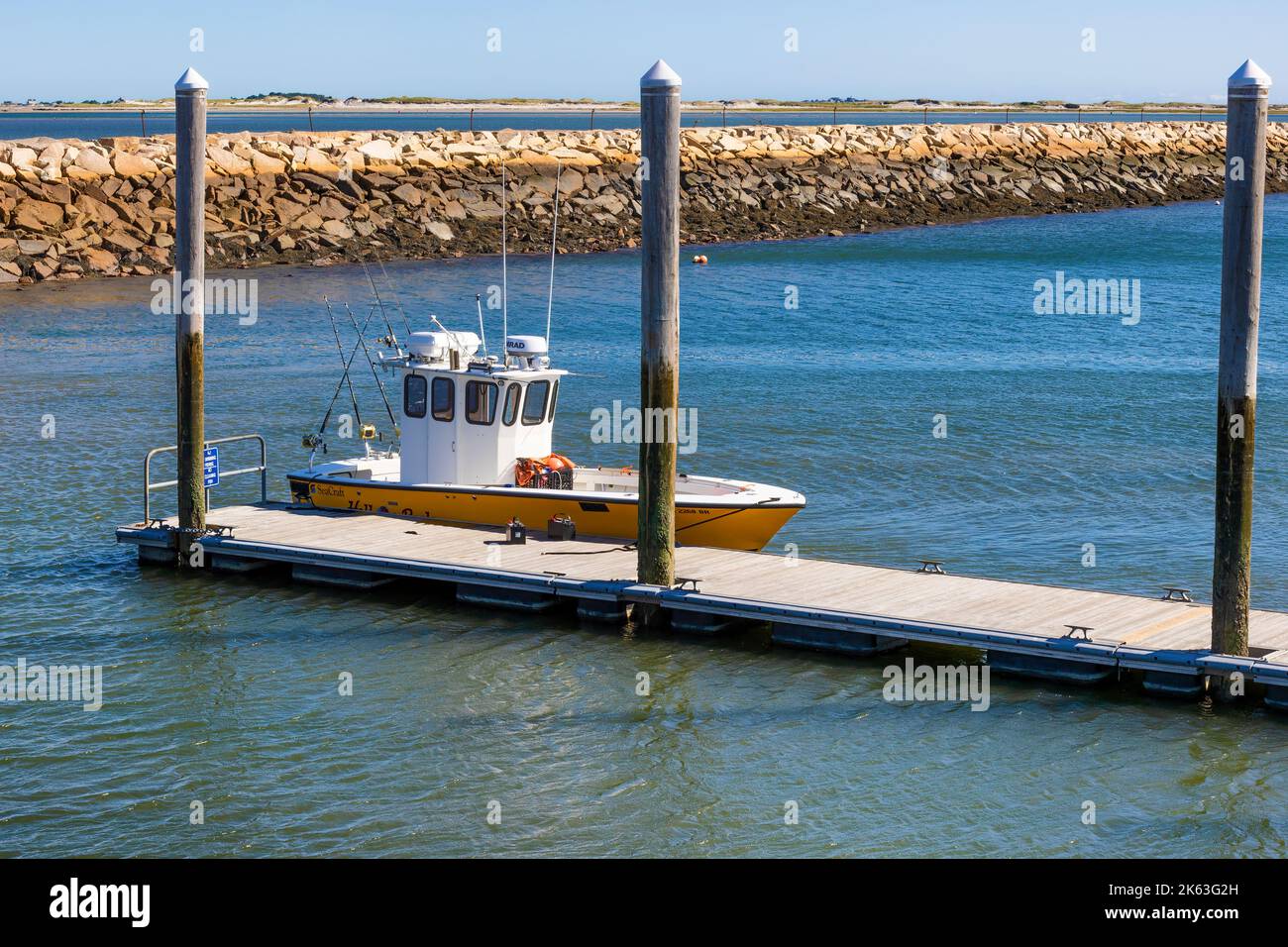 Plymouth, Massachusetts, USA - September 15, 2022:A fishing boat docked in Plymouth Harbor the dike in the background on a sunny day. Stock Photo