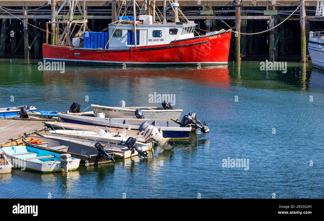 Plymouth, Massachusetts, USA - September 15, 2022: fishing boat docked at pier and tender boats docked to a dock in the Harbor. Stock Photo