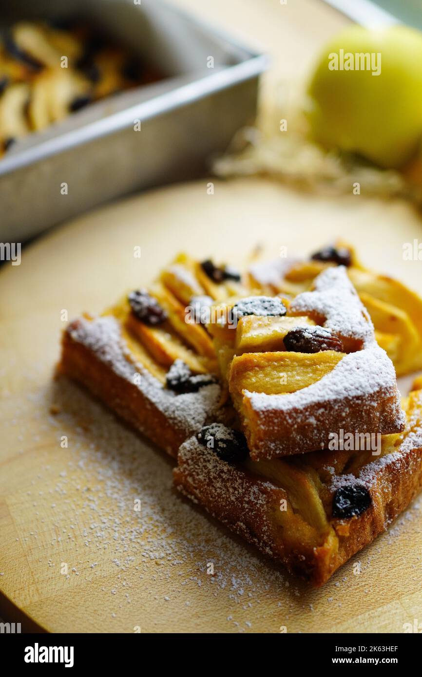 Homemade apple cake with raisins sprinkled with powdered sugar Stock Photo