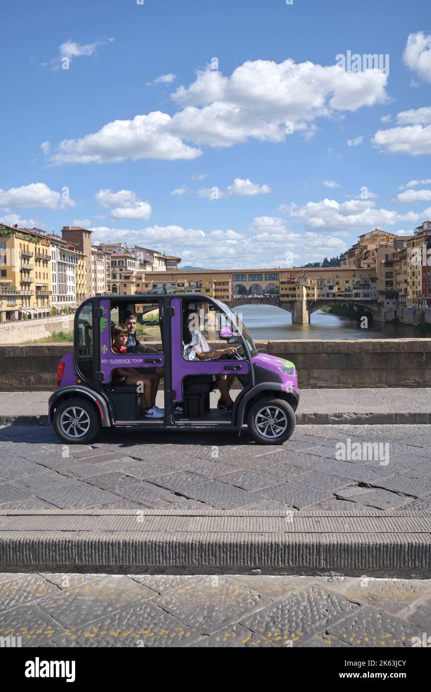 Tourists on Eco Florence Tour in electric car crossing Ponte Santa Trinita in Florence Italy Stock Photo
