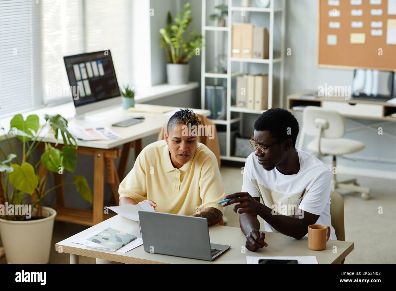 High angle portrait of two African American business people using laptop together in IT office and wearing casual clothes Stock Photo