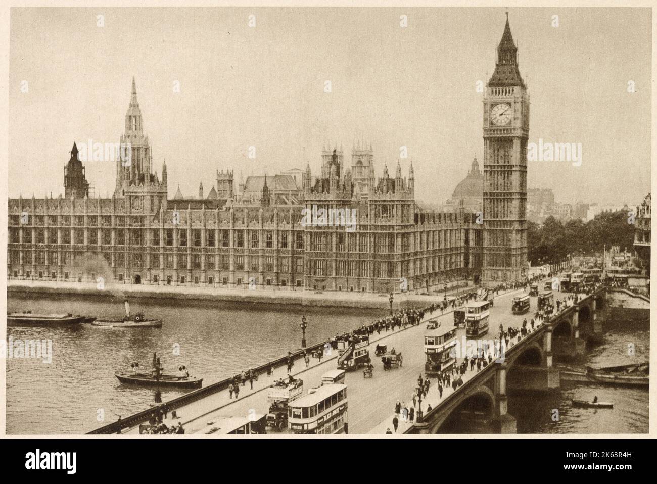 Photograph showing busy Westminster Bridge with pedestrians walking across and a steady flow of traffic made up of public transport trams, omnibuses and some horse and carts. Stock Photo