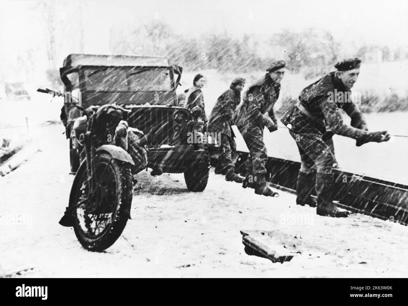 Polish soldiers crossing a river while towing a Jeep in bad weather on the Western Front during World War II. The Allied forces had to not only deal with the enemy but also the cold and the snow. Stock Photo