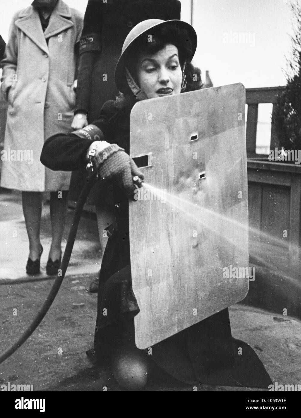 West End stage and film star, Miss Judy Campbell, learns how to use a stirrup pump on the roof of a Park Lane block of flats where she takes a regular turn at firewatching. Stock Photo