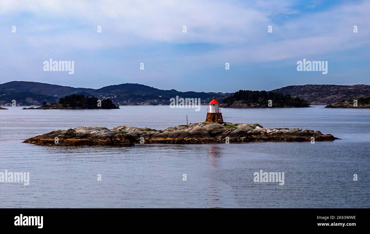 The small islet and lighthouse on Fleslandskjaeret, outside Flesland near Bergen, Norway. Stock Photo