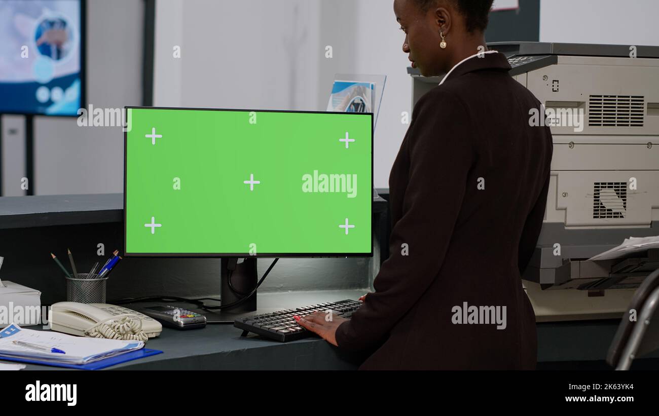 Receptionist Screen African american receptionist using greenscreen on computer, working at ...
