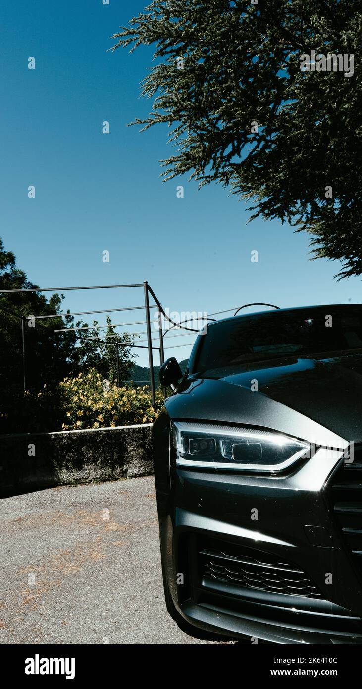 A vertical shot of the half side of a black car parked in the street on ...