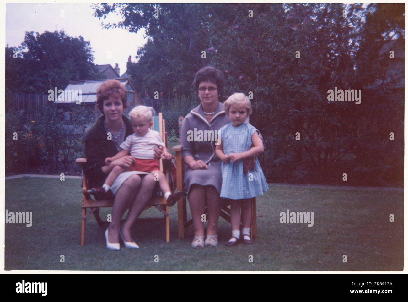 A Mother, her daughter and two other young relatives (nieces?) in a smart and tidy suburban back garden - August, 1961 Stock Photo