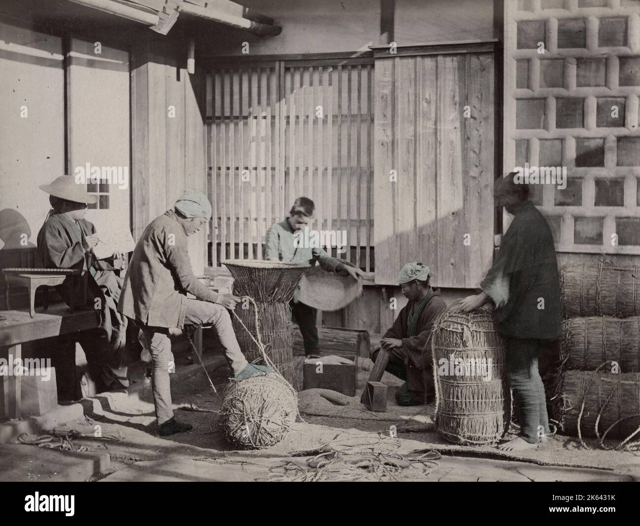 Farm workers packing bales of rice, Japan, late 19th century. Stock Photo