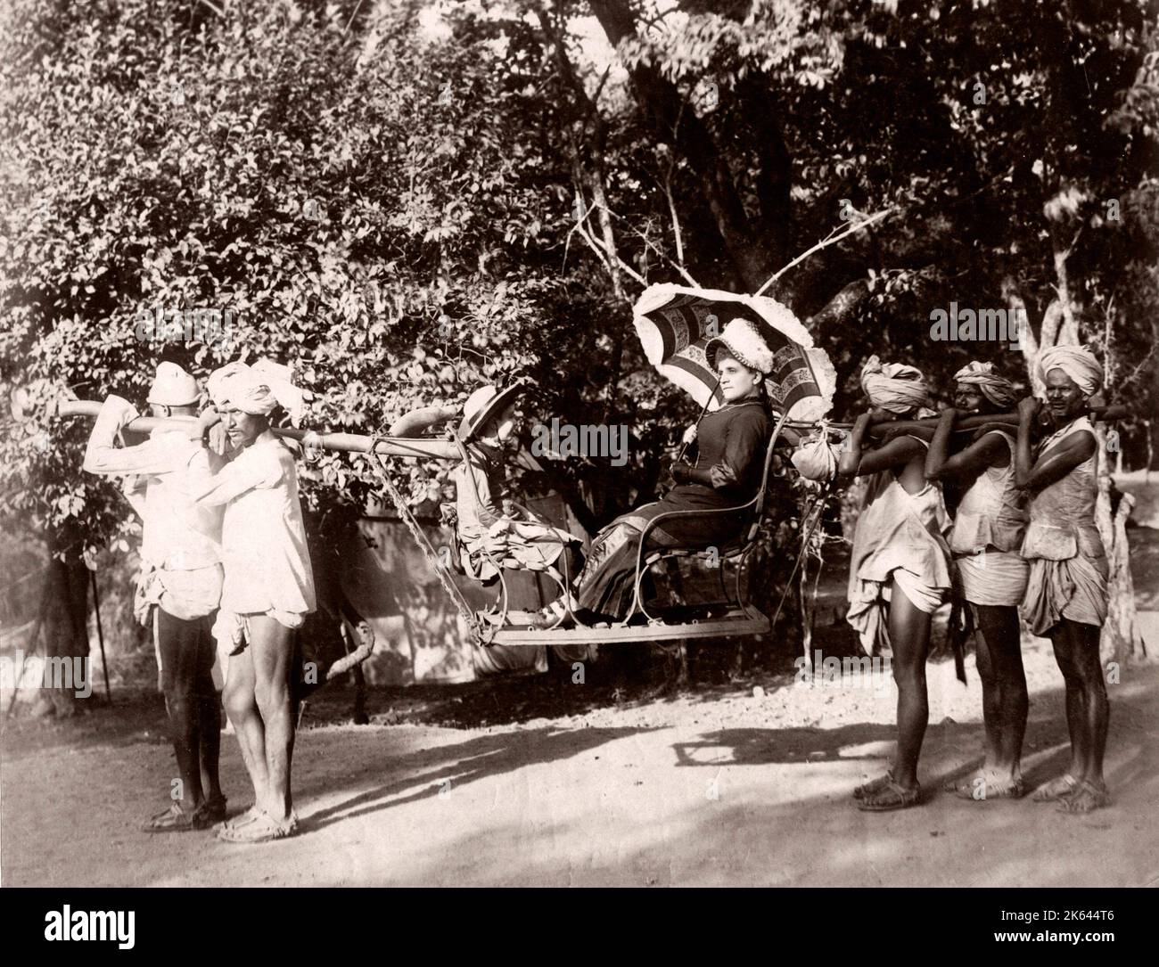 India - woman in a Sedan chair, carrying chair, with porters. Stock Photo