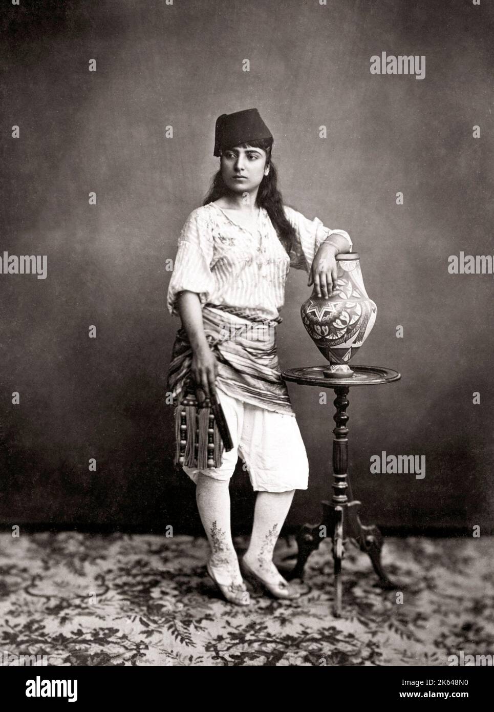 Young Turkish woman with ornate stockings and vase, Turkey, c.1880's Stock Photo