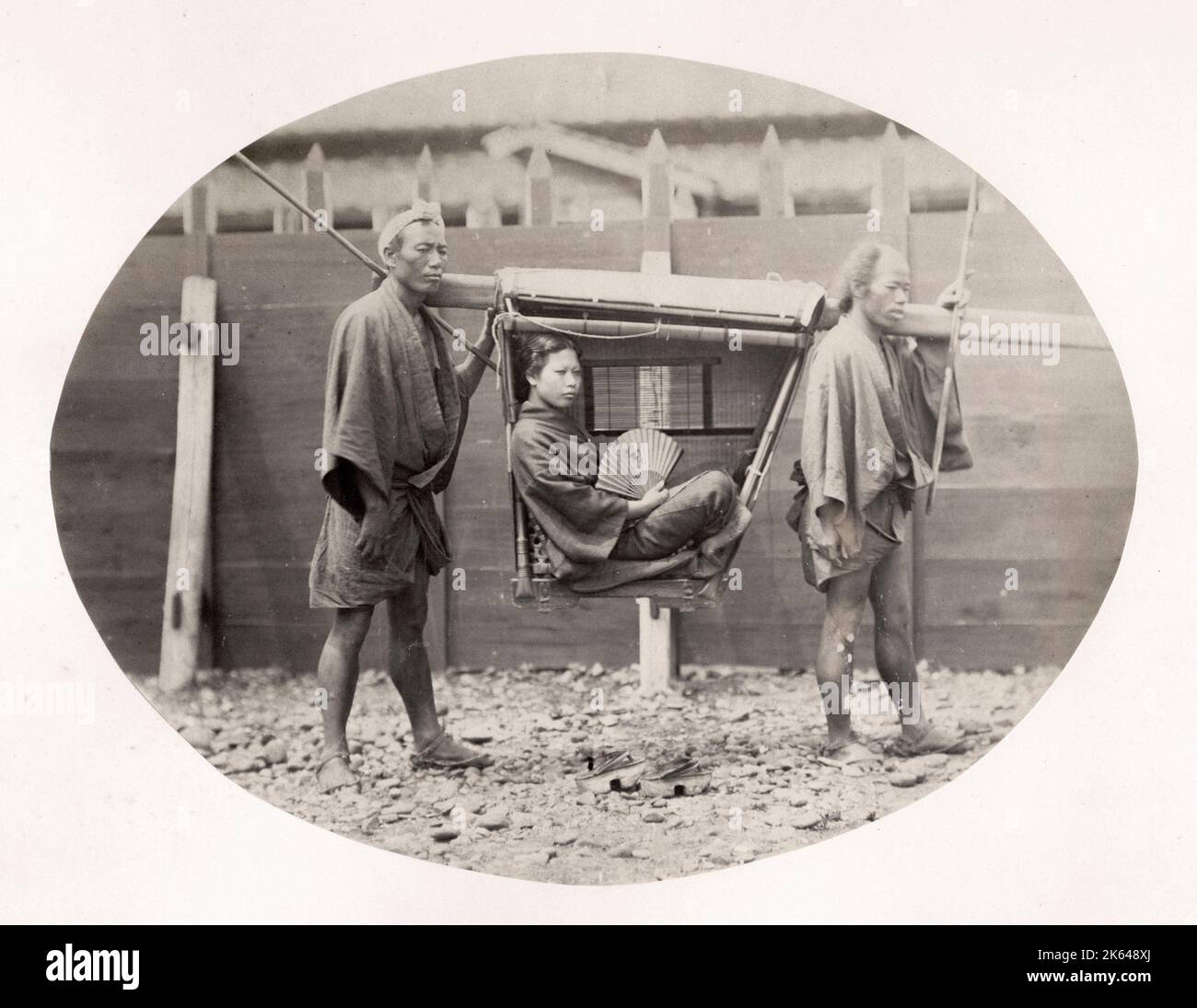 Vintage late 19th century photograph: Japanese woman in a kago, carrying chair, Japan, c.1870's. Stock Photo