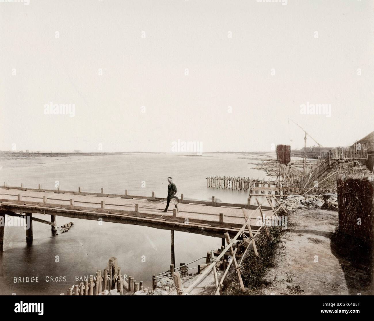 Vintage 19th century photograph: wooden bridge across a wide river ...