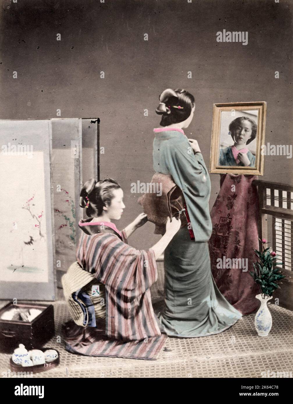 Late 19th century vintage photograph: Geisha having her obi sash tied, Japan Stock Photo