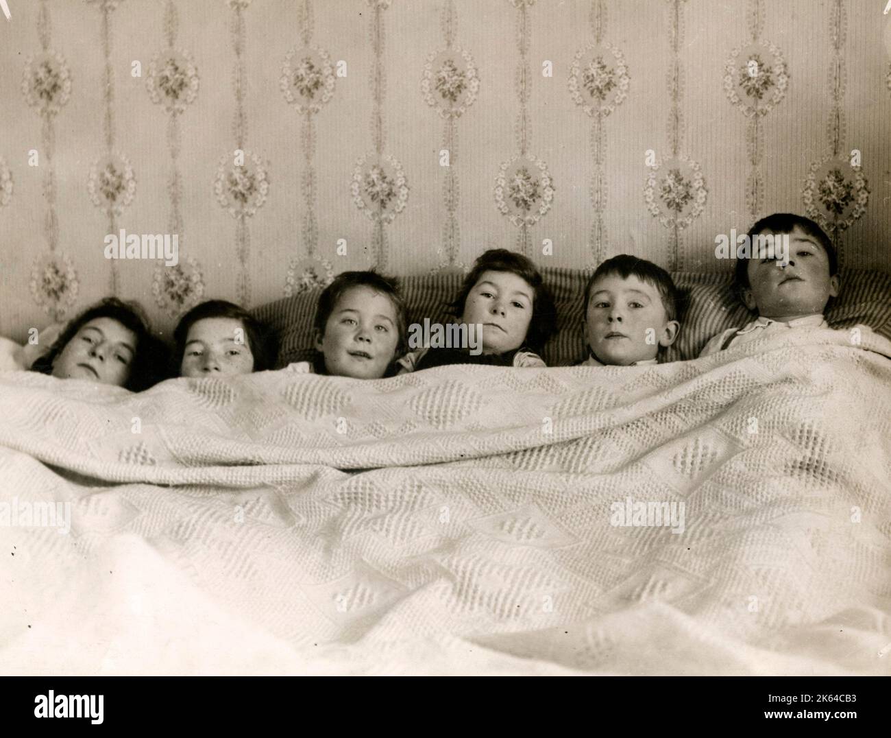 Six children from a family of 14 sharing a bed in a Salvation Army hostel in the UK, c1920s