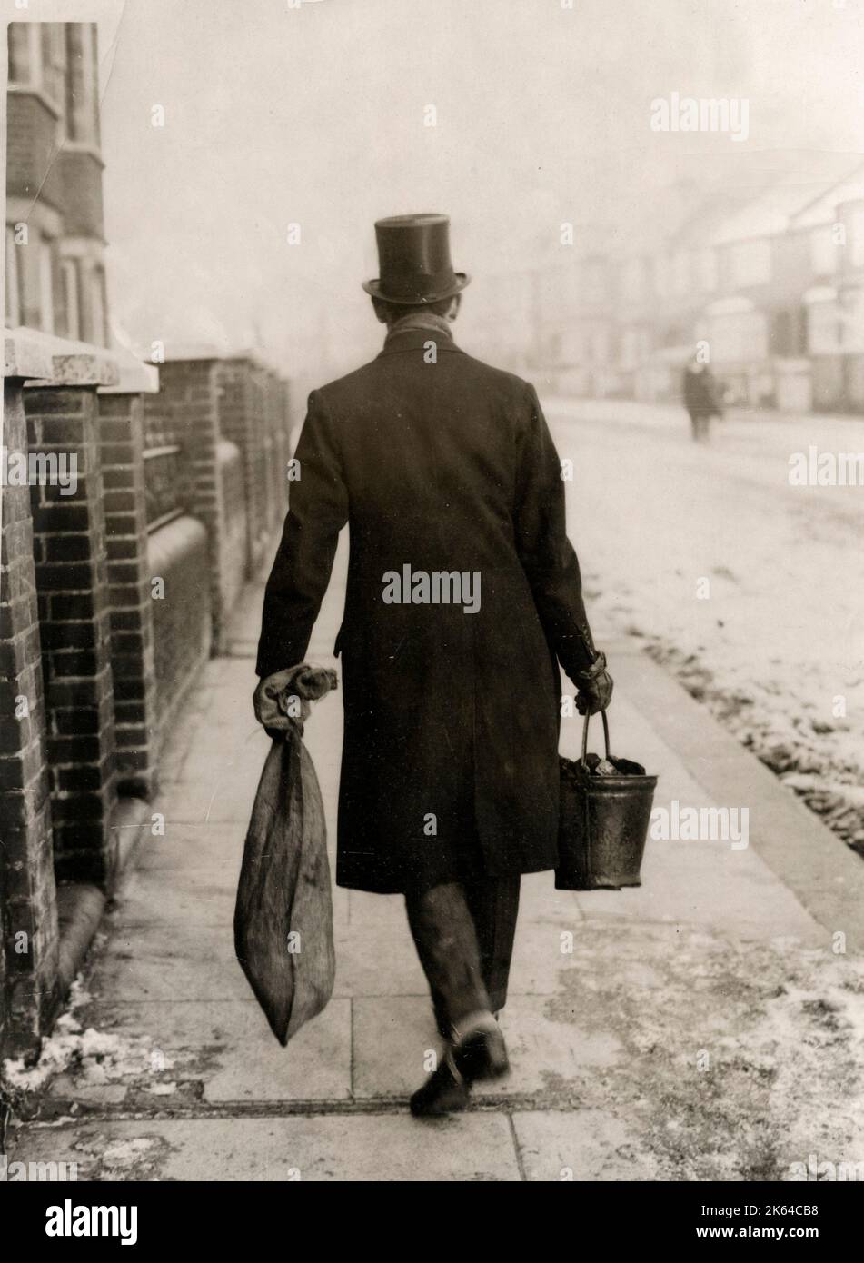 Coal shortage during the miners strike of 1926 - a city gentleman is forced to carry his own coal home during the industrial unrest and shortages of 1926. Stock Photo