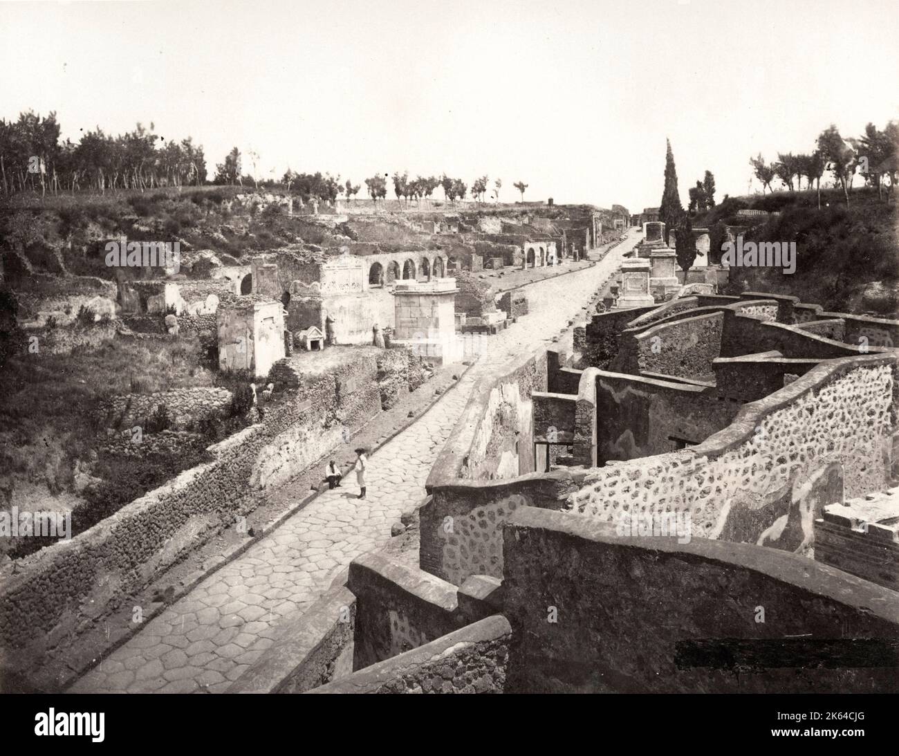 Vintage 19th century photograph - Street of Tombs, Pompeii, Italy. The Street of Tombs ran from the Herculaneum Gate on the road leading towards Herculaneum. It was forbidden to bury bodies inside the walls of Pompeii and so this street, which is outside of the city, has over thirty tombs in it. It was a busy road for travellers and so also had shops along it. Stock Photo