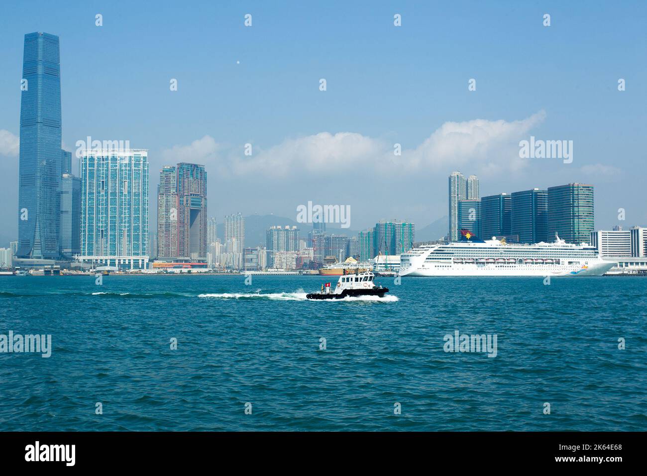 Sunny view on Kowloon district    from   Central Pier No.10   of HongKong island  and Victoria harbour: skyscrapers and ships on parking Stock Photo