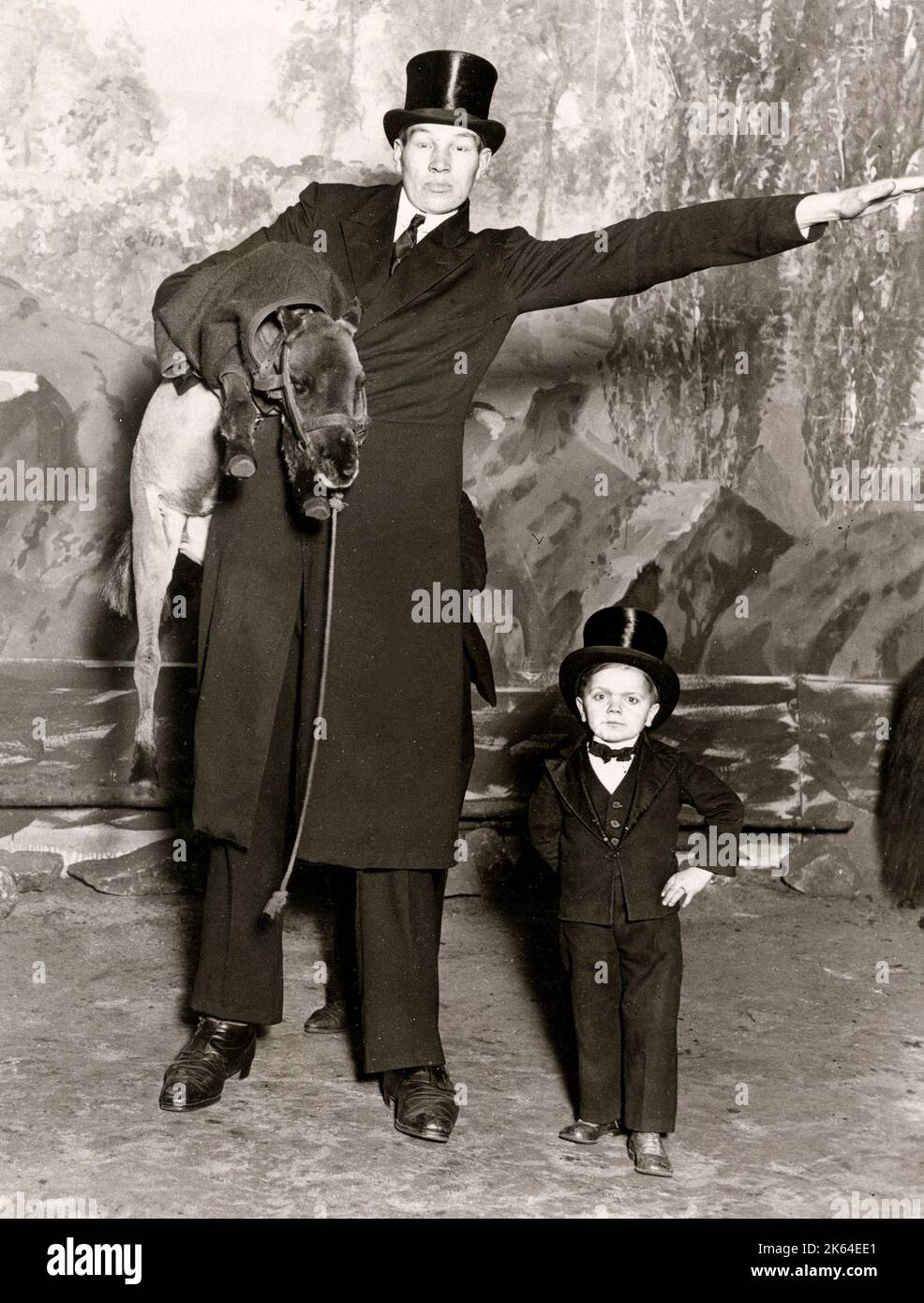 Early 20th century vintage press photograph - sideshow freak show - dwarf and giant, London c.1920s - Olympia Circus Stock Photo
