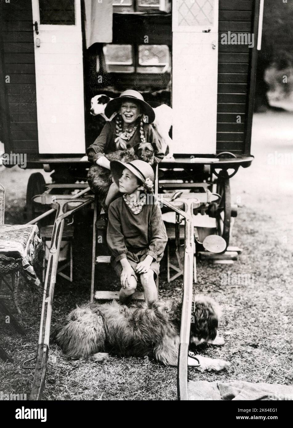 Early 20th century vintage press photograph - two young girls and their dog on holiday in a horse drawn carvan, England, c.1920 Stock Photo