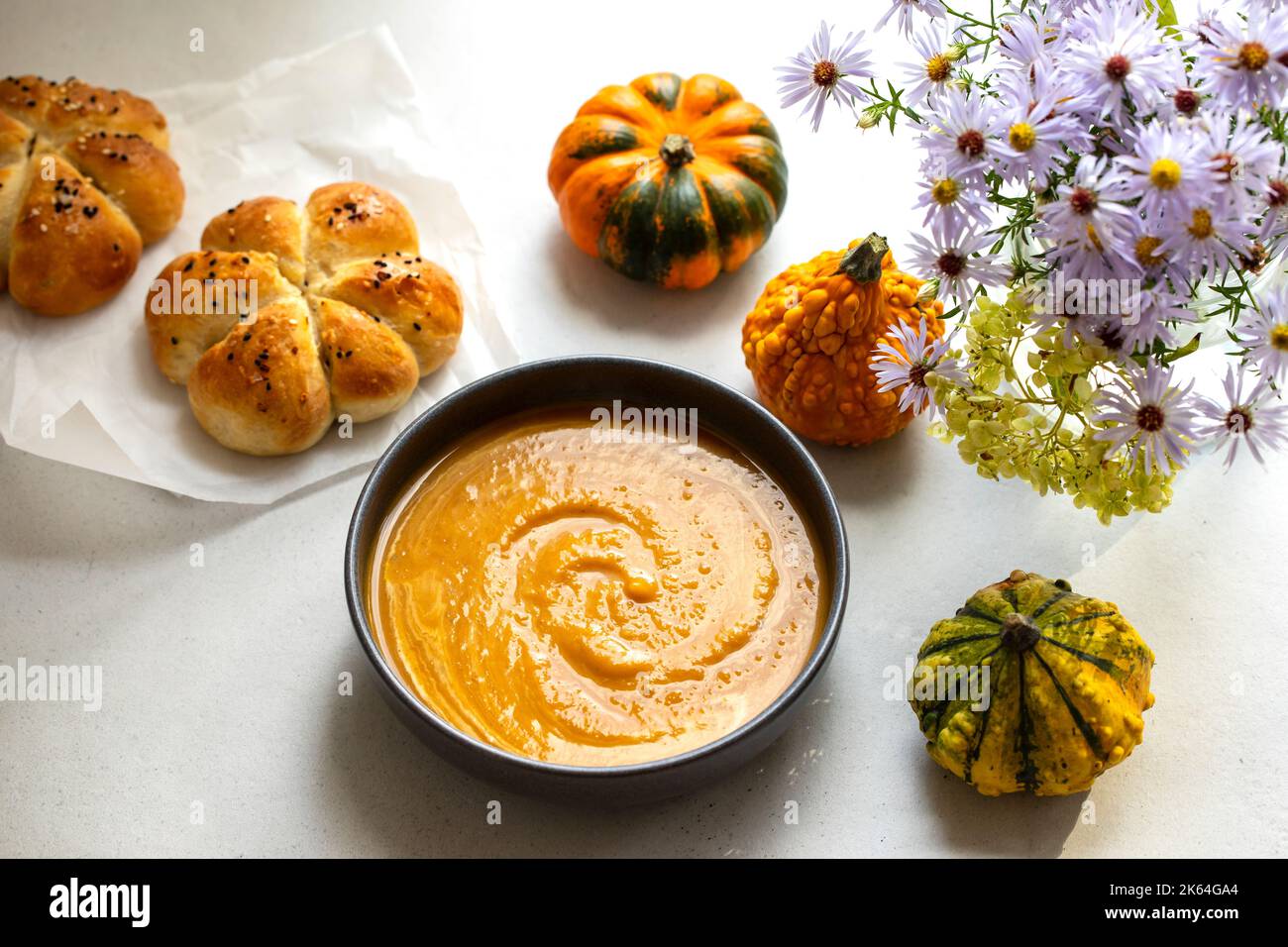 Pumkin soup with freshly baked bread roll Stock Photo