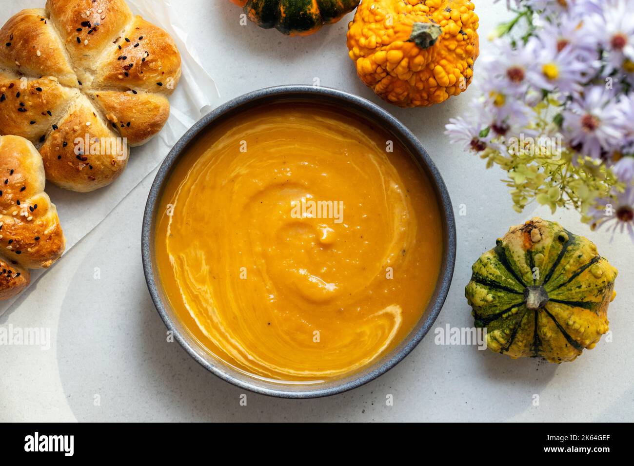 Pumkin soup with freshly baked bread roll Stock Photo