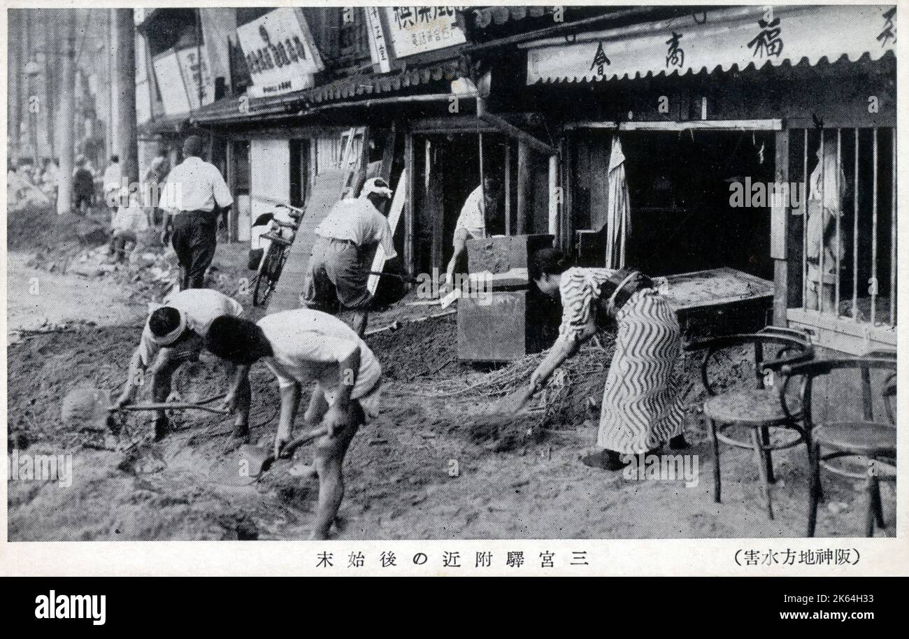 Flooding in Japan (3/3). Clearing up the mess left against shopfront following the deluge. Possibly the Great Kanto Flood of 1910? Stock Photo
