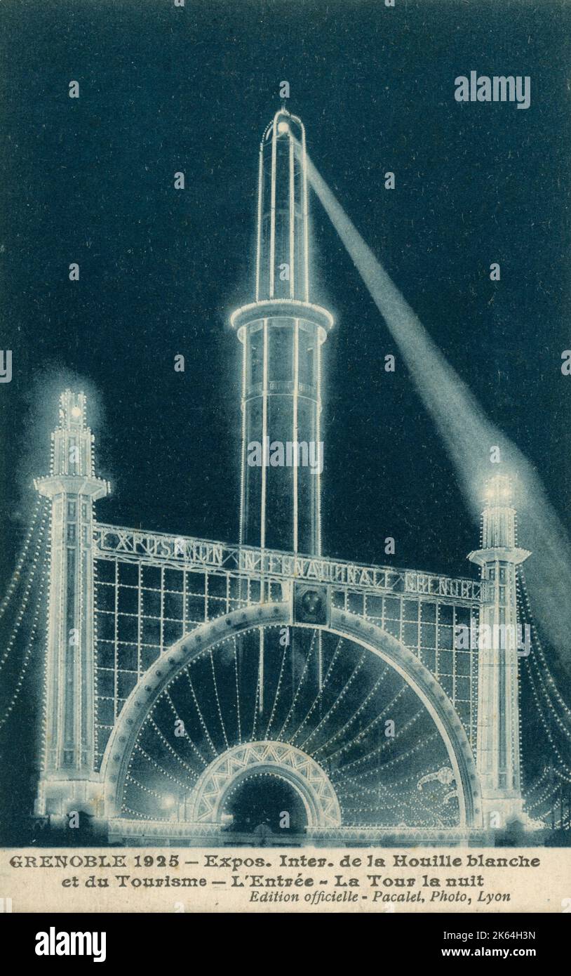 Grenoble 1925 Exposition Internationale de la Houille blanche et du Tourisme (International Exhibition of Hydropower and Tourism) - The Grand Entrance Gateway and Perret tower (originally called La tour pour regarder les montagnes 'The tower for looking at the mountains') at night. Stock Photo