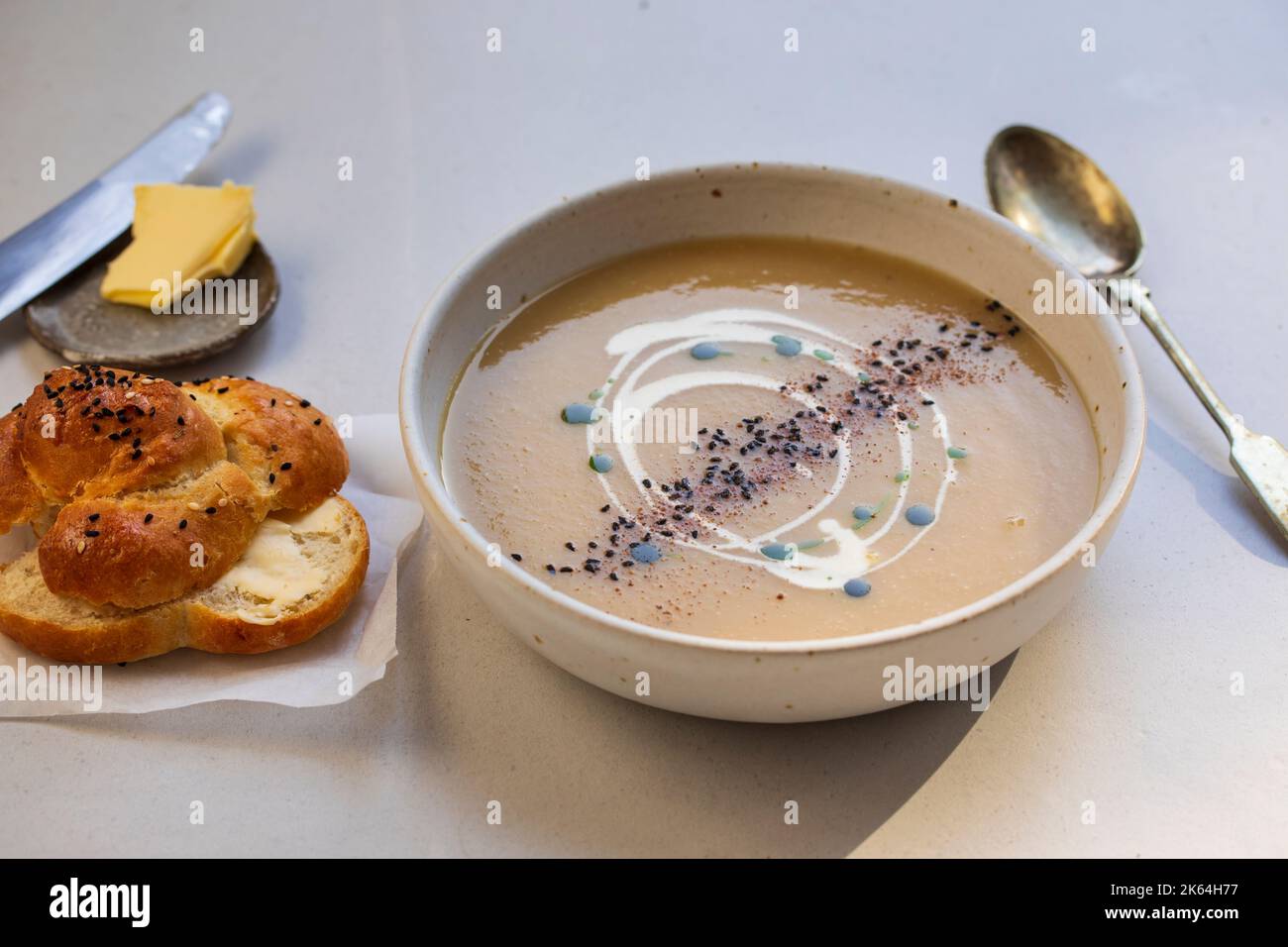 Creamy celeriac soup with parssley oil and black onion seeds Stock Photo
